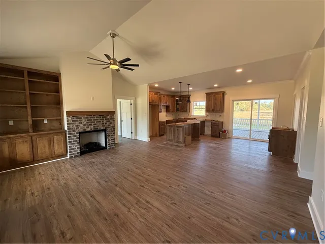 a view of a livingroom with furniture a fireplace and wooden floor