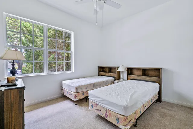 a bedroom with two beds and a large window