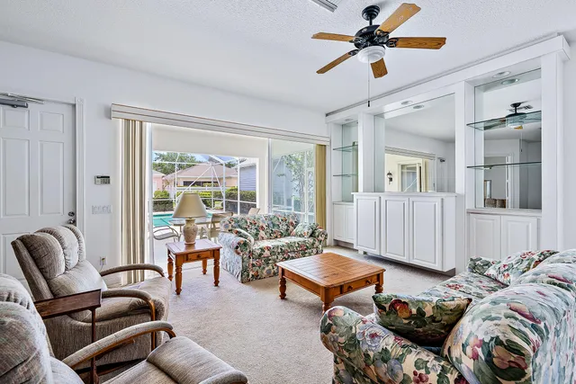 a living room with furniture ceiling fan and a window