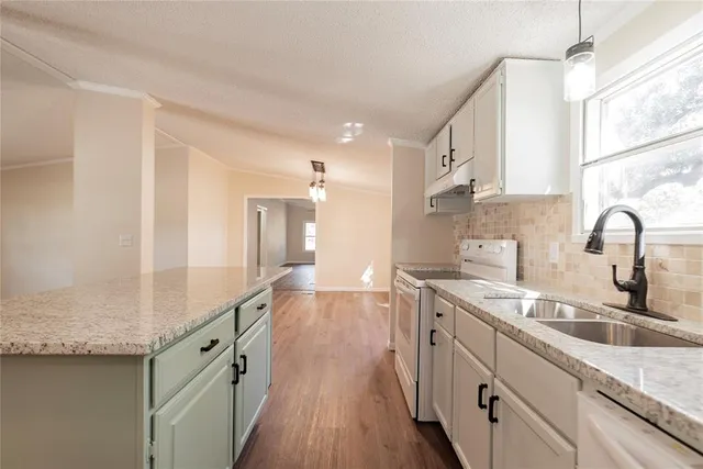 a kitchen with a sink cabinets and wooden floor