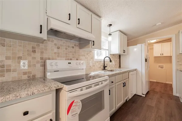 a kitchen with a sink stove and cabinets