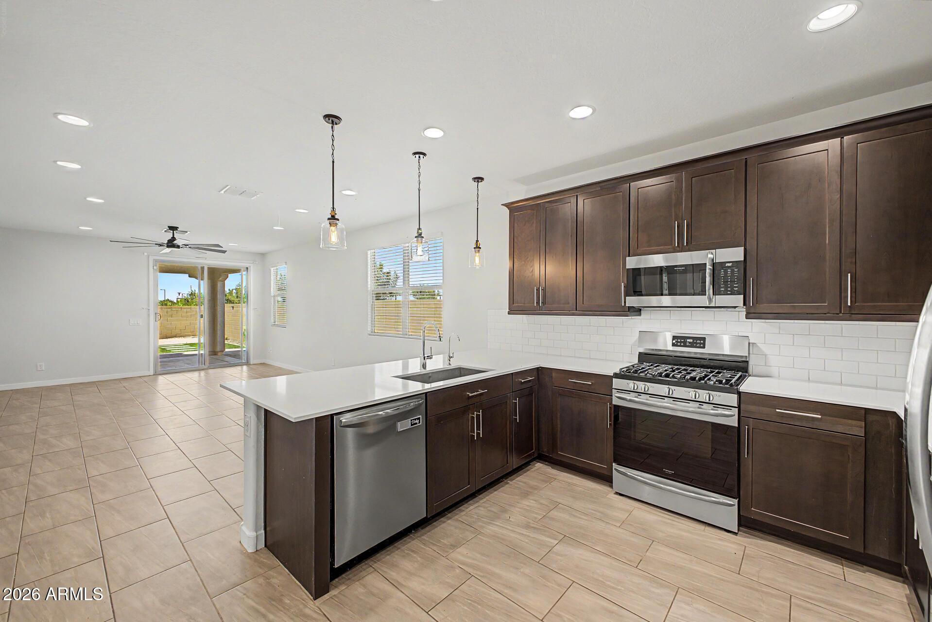 23080 East Stacey Road Queen Creek, AZ 85142 - Photo 6 of 42 a kitchen with stainless steel appliances granite countertop a stove a sink and a refrigerator