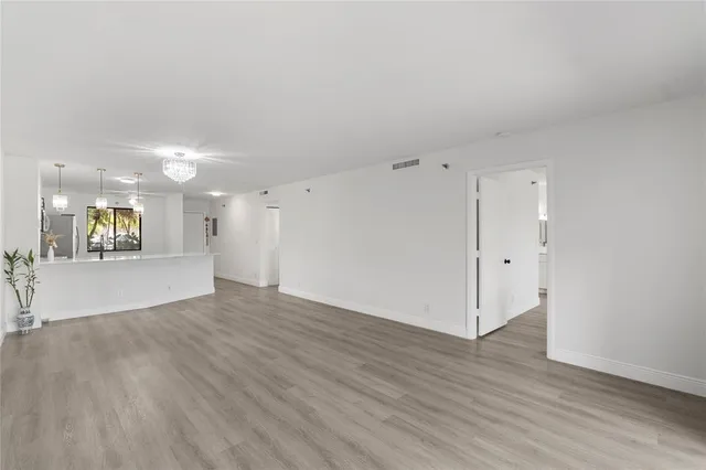 an empty room with wooden floor and window