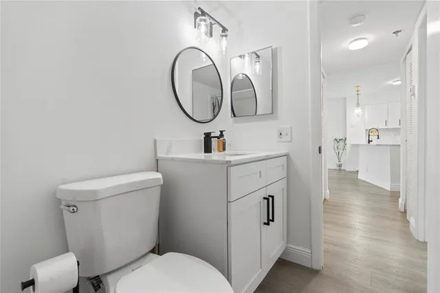 an empty room with wooden floor chandelier fan and windows