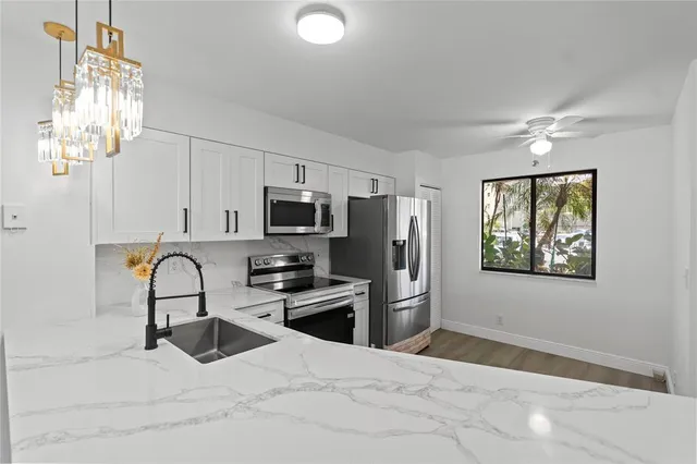 a kitchen with stainless steel appliances a refrigerator stove and sink