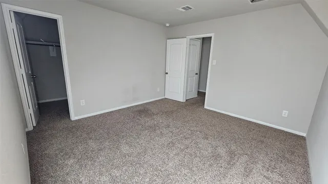 an empty room with closet and mirror