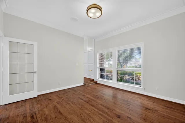 an empty room with wooden floor and window