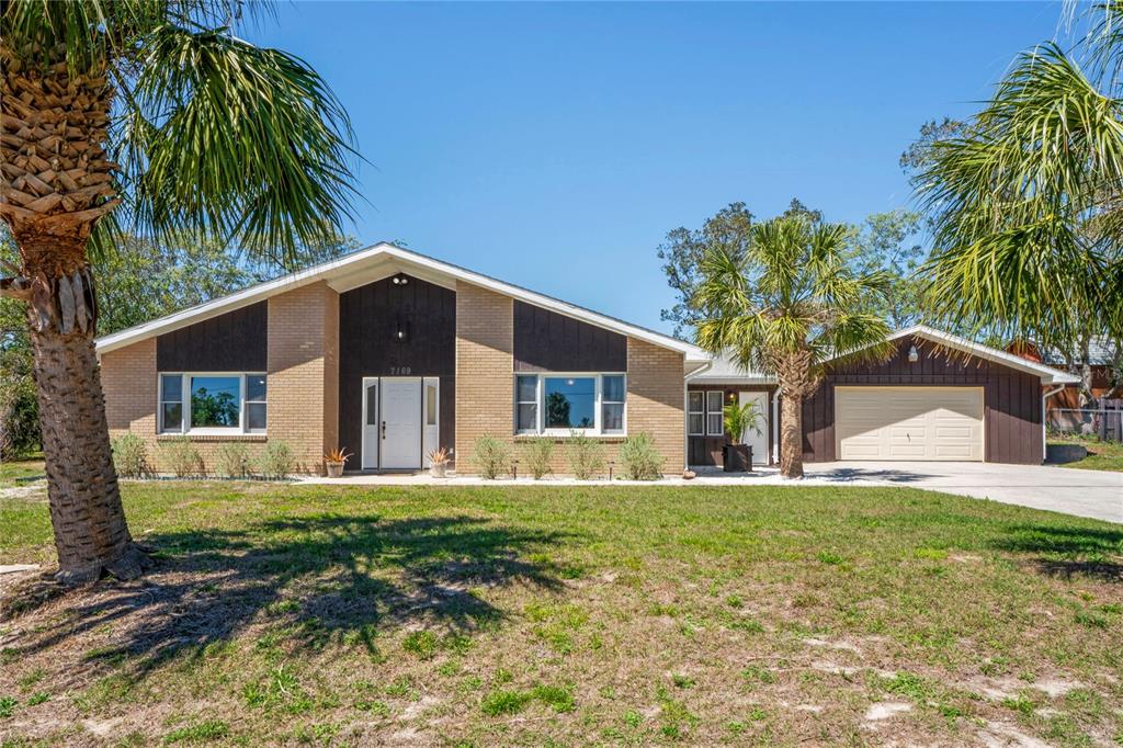 7169 Spruce Drive Weeki Wachee, FL 34607 - Photo 1 of 1 a front view of a house with a yard