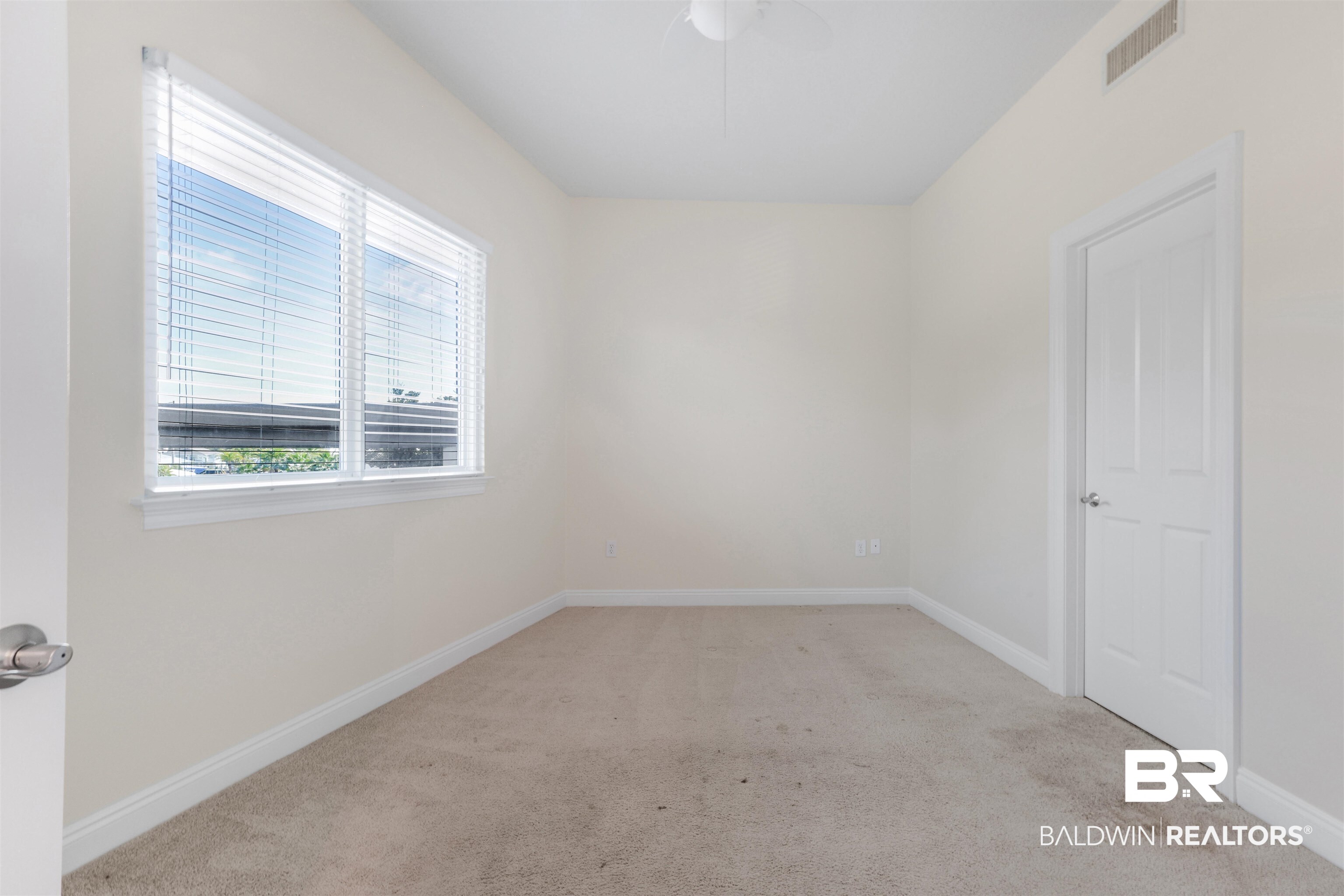 28250 Canal Road, Unit 106 Orange Beach, AL 36561 - Photo 28 of 50 Spare room with light colored carpet and a ceiling fan