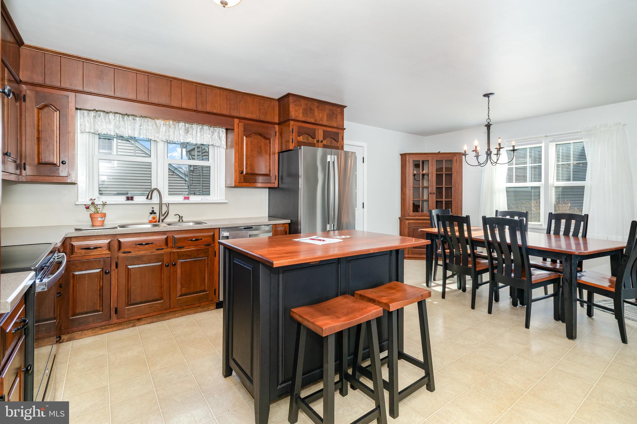 202 North Decatur Street Strasburg, PA 17579 - Photo 7 of 30 a kitchen with stainless steel appliances granite countertop wooden cabinets a dining table and chairs