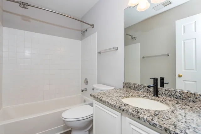 a bathroom with a granite countertop sink toilet and shower