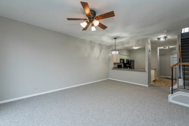 an empty room with wooden floor and a ceiling fan