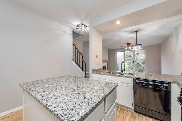 a kitchen with kitchen island granite countertop a sink stove and refrigerator