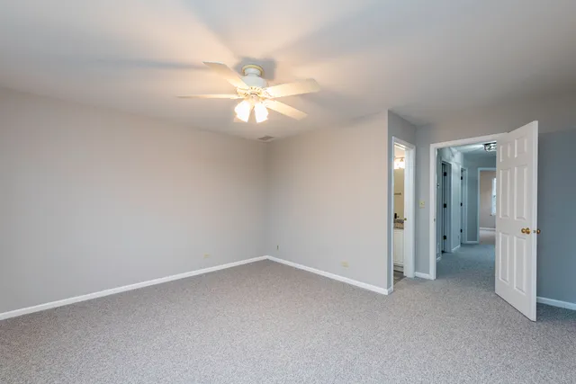 an empty room with a ceiling fan and a window