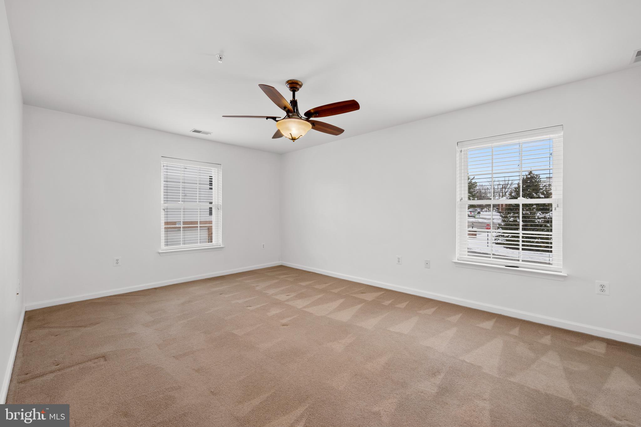 6508 Ridenour Way East, Unit 2A Sykesville, MD 21784 - Photo 11 of 20 an empty room with windows and ceiling fan