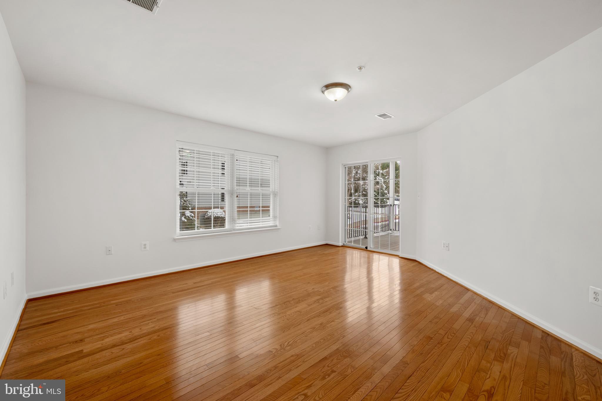 6508 Ridenour Way East, Unit 2A Sykesville, MD 21784 - Photo 2 of 20 a view of an empty room with wooden floor and a window