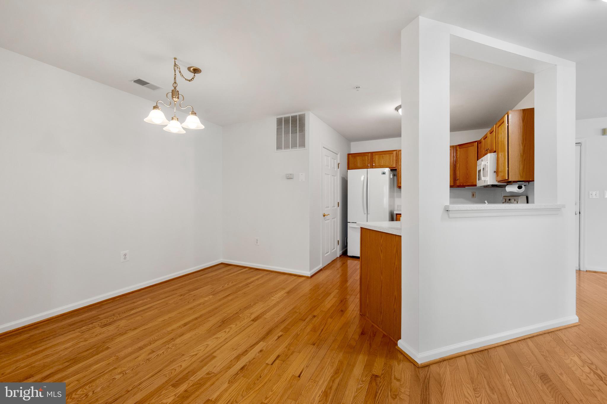 6508 Ridenour Way East, Unit 2A Sykesville, MD 21784 - Photo 8 of 20 wooden floor in an empty room with a window
