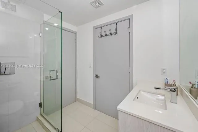 a bathroom with a sink a shower and a mirror