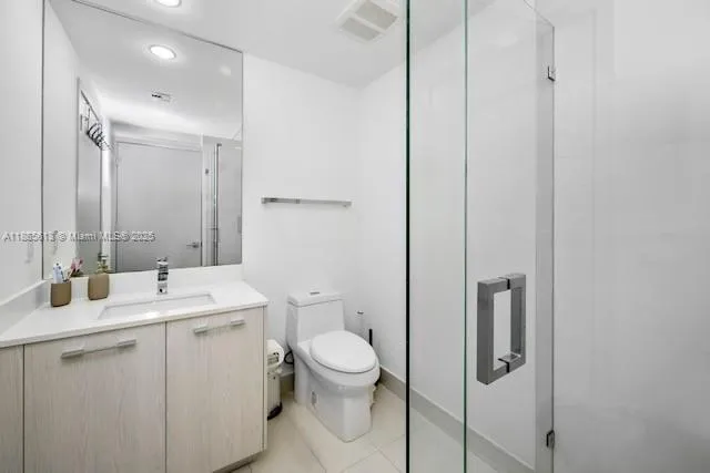 a bathroom with a double vanity sink toilet and mirror