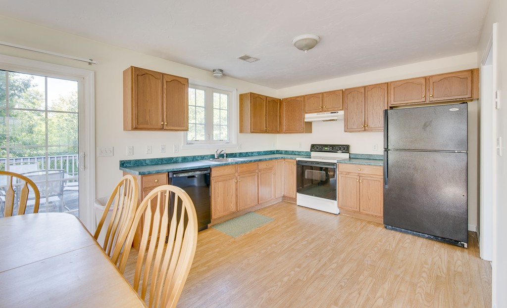 12 Hamilton Way Holbrook, MA 02343 - Photo 5 of 13 a kitchen with stainless steel appliances granite countertop a refrigerator a sink dishwasher a stove and a dining table with wooden floor
