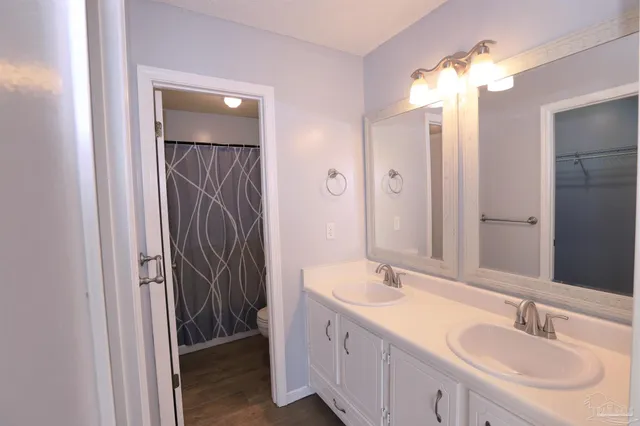 a bathroom with a double vanity sink mirror and shower