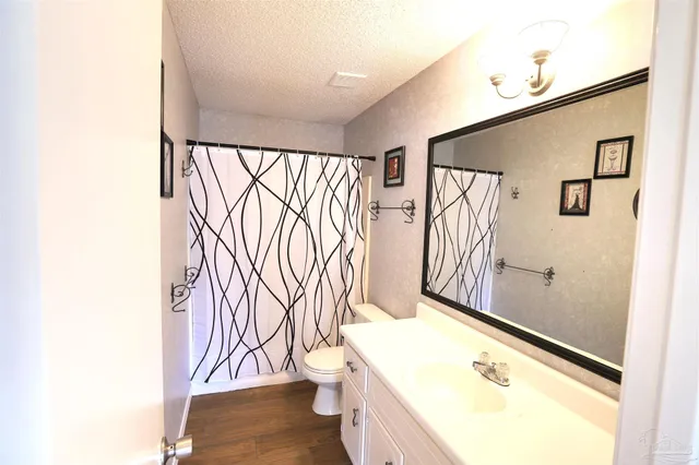 a bathroom with a granite countertop sink and a large mirror