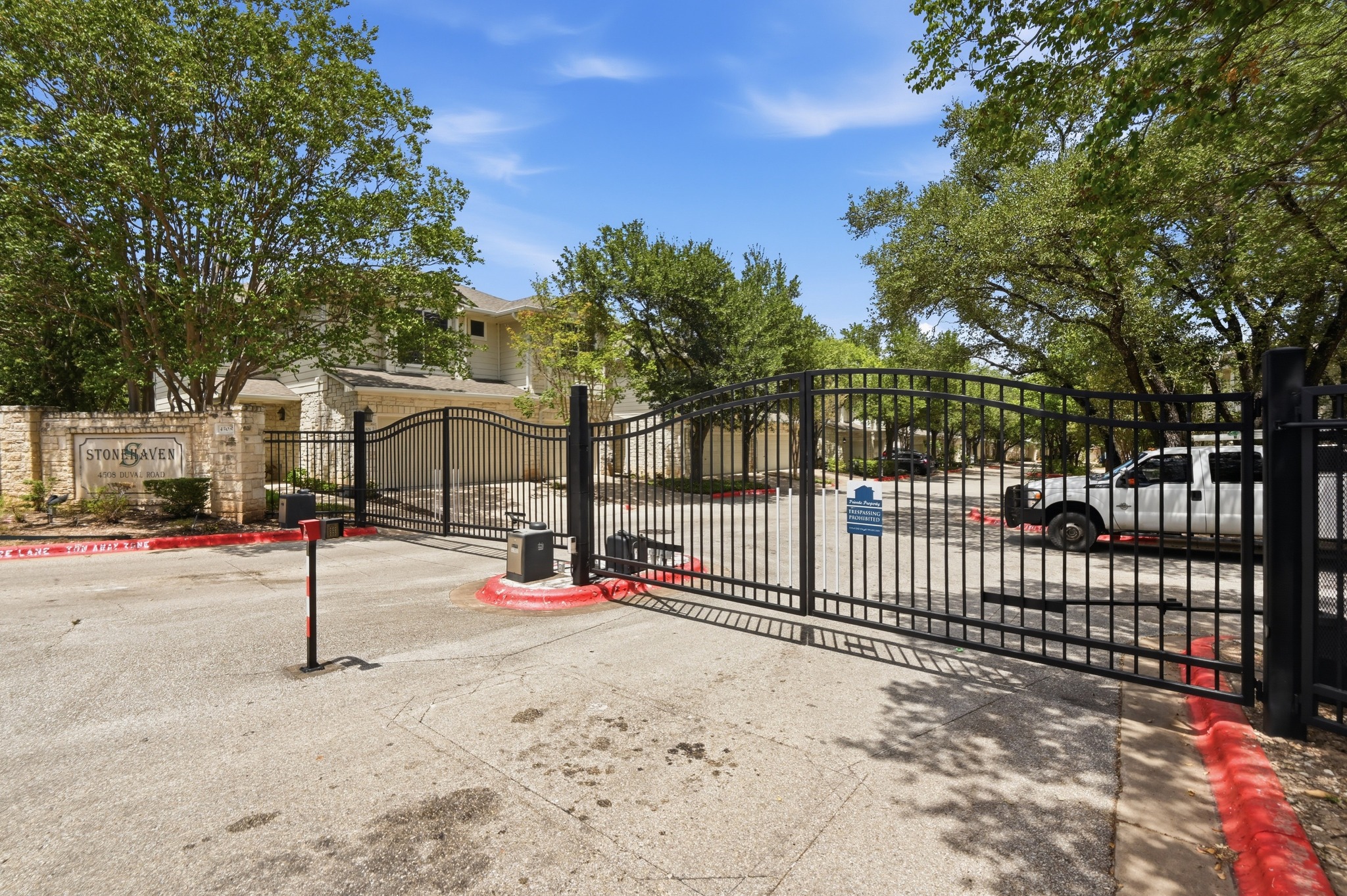 4508 Duval Road, Unit 4401 Austin, TX 78727 - Photo 24 of 26 A secure gated entrance welcomes residents with a stone monument sign and paved access roads.