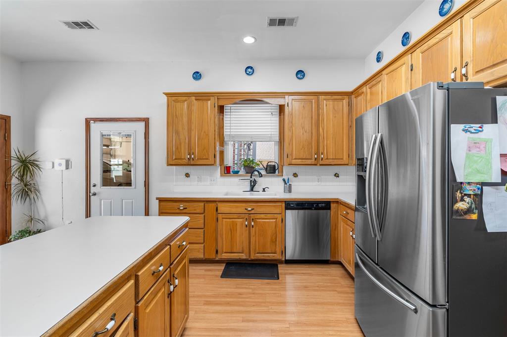 4502 Dexham Road Rowlett, TX 75088 - Photo 15 of 39 a modern kitchen with stainless steel appliances granite countertop a refrigerator and a sink