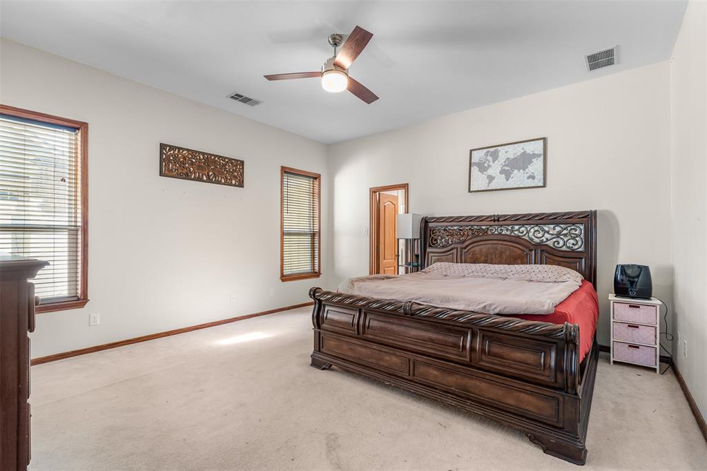 4502 Dexham Road Rowlett, TX 75088 - Photo 20 of 39 a bedroom with a bed and a chandelier