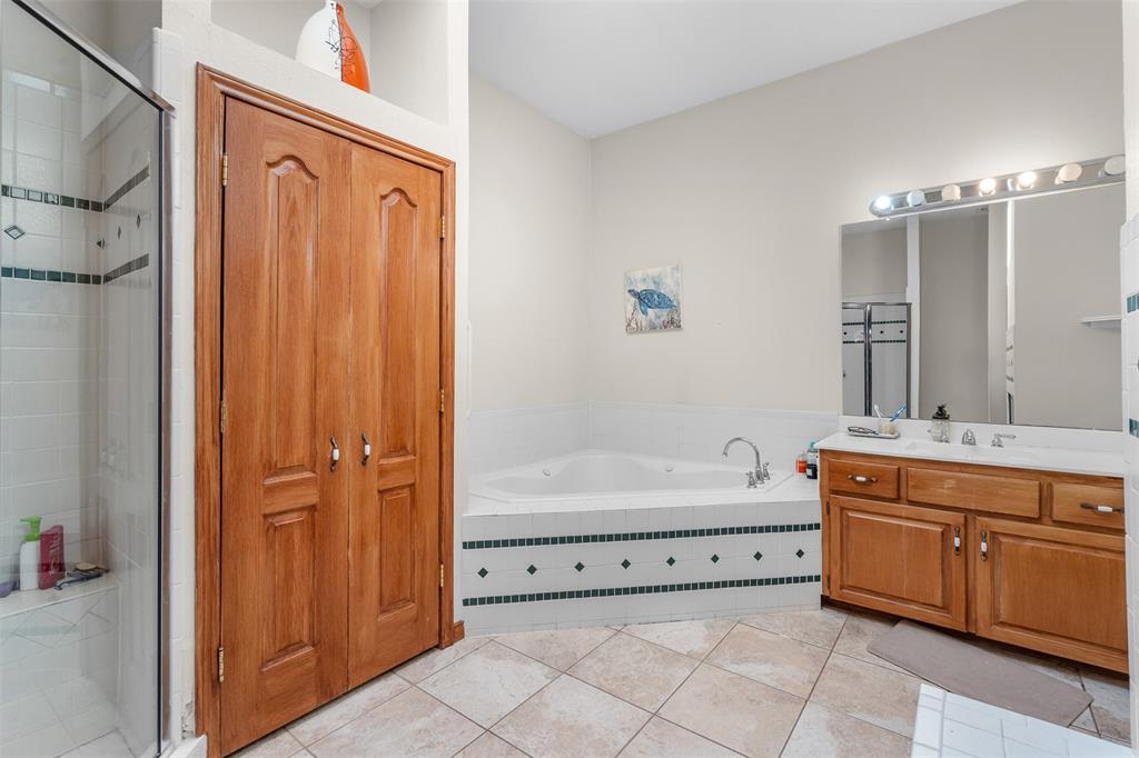 4502 Dexham Road Rowlett, TX 75088 - Photo 23 of 39 a bathroom with a tub sink and mirror