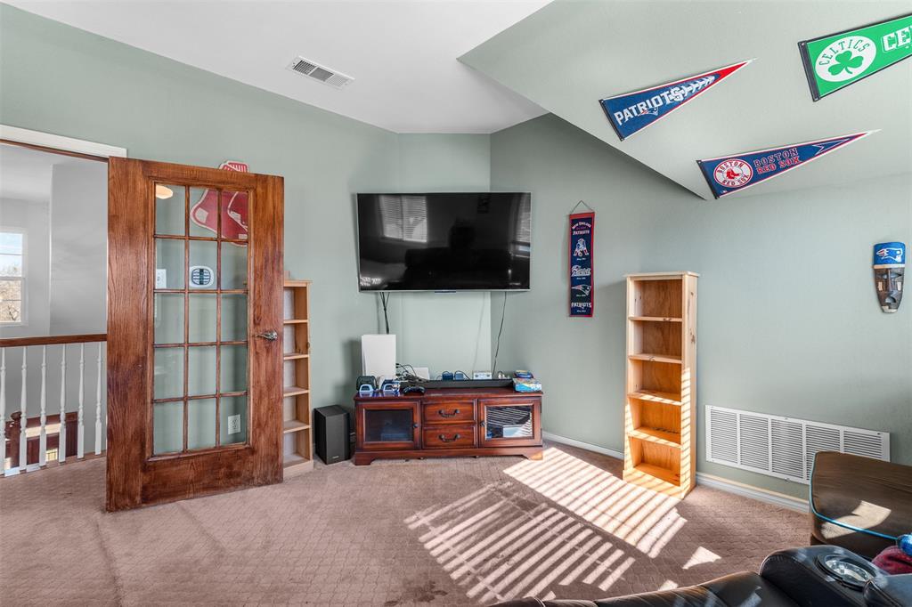 4502 Dexham Road Rowlett, TX 75088 - Photo 28 of 39 a bedroom with furniture and a flat screen tv