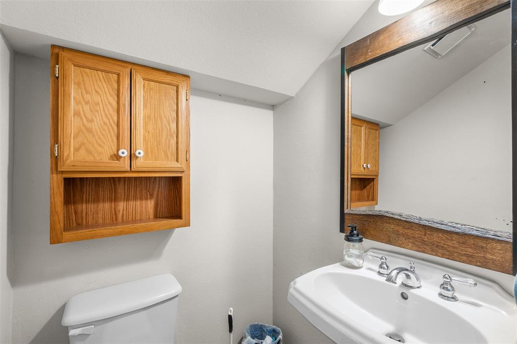 4502 Dexham Road Rowlett, TX 75088 - Photo 7 of 39 a bathroom with a sink a toilet and a mirror