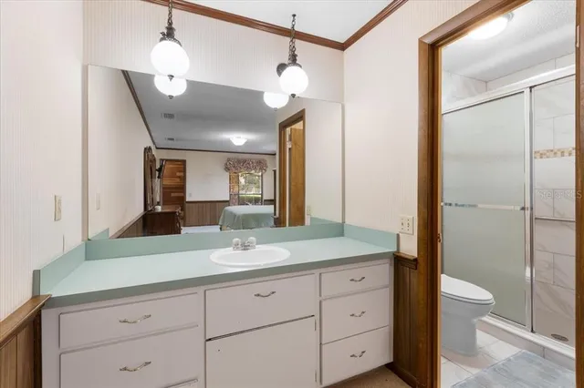 a spacious bathroom with a granite countertop sink a toilet and a mirror