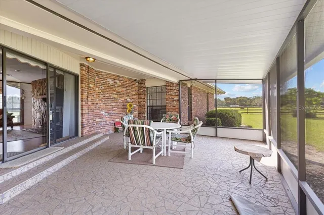 a dining room with furniture and large windows
