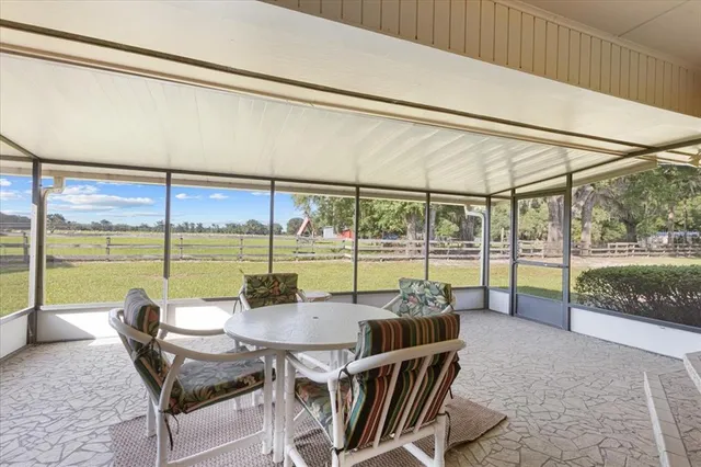 a dining room with furniture and a floor to ceiling window