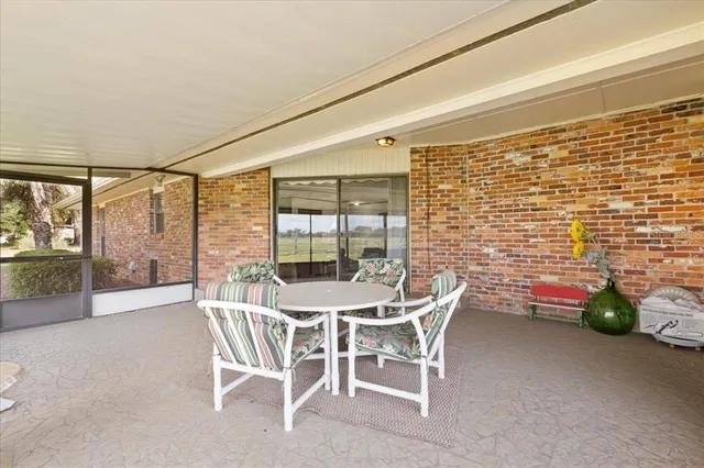 a dining room with furniture and a floor to ceiling window