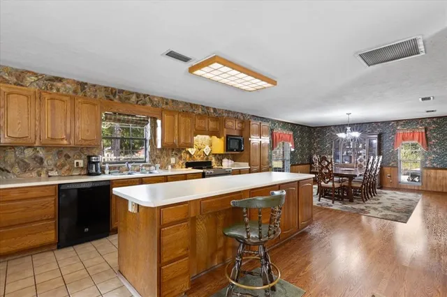 a kitchen with stainless steel appliances granite countertop sink stove and wooden cabinets