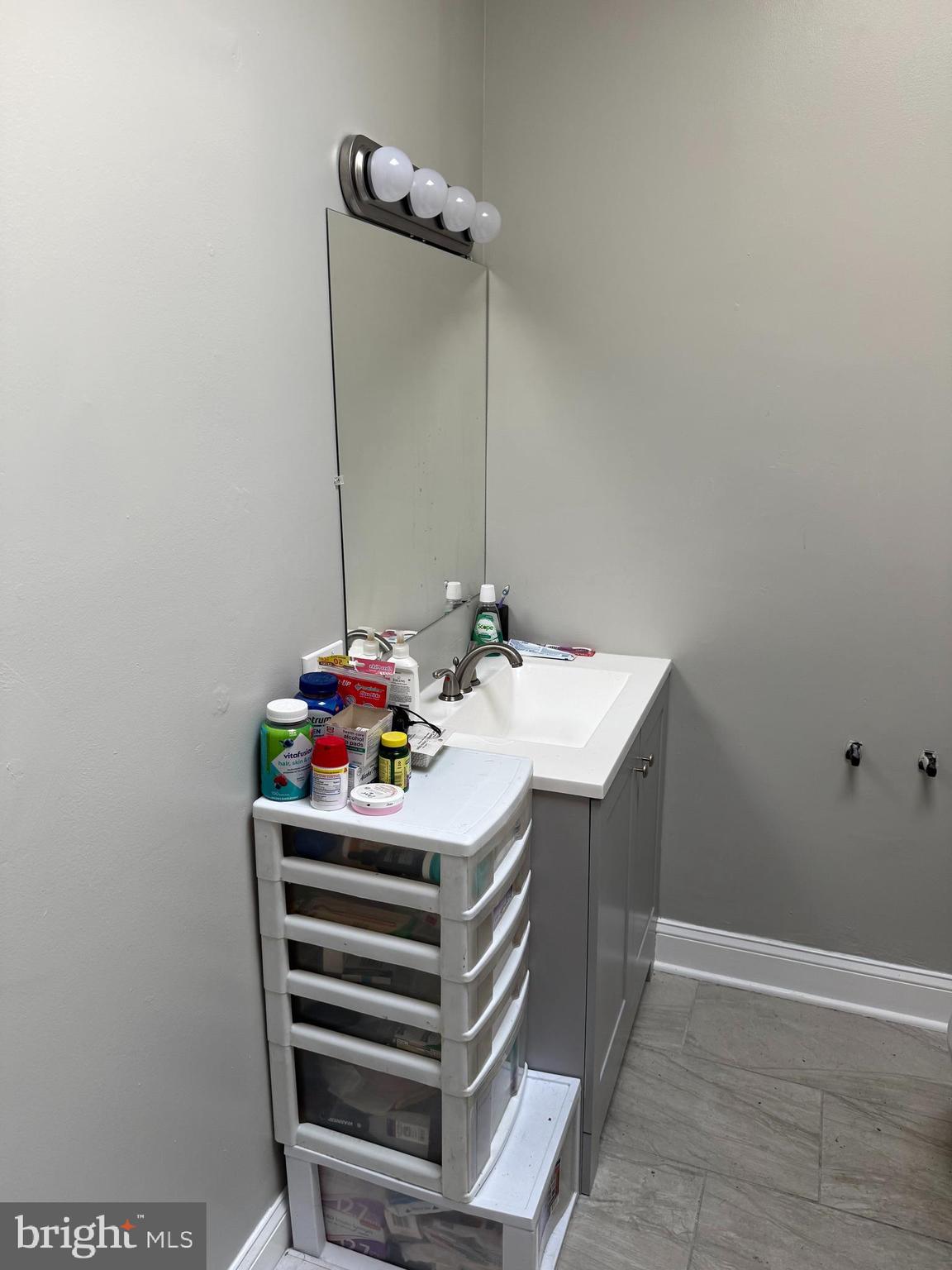 2921 Baker Street Baltimore, MD 21216 - Photo 3 of 7 a bathroom with a sink and a mirror