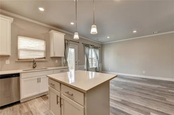 a kitchen with a sink chandelier and wooden floor