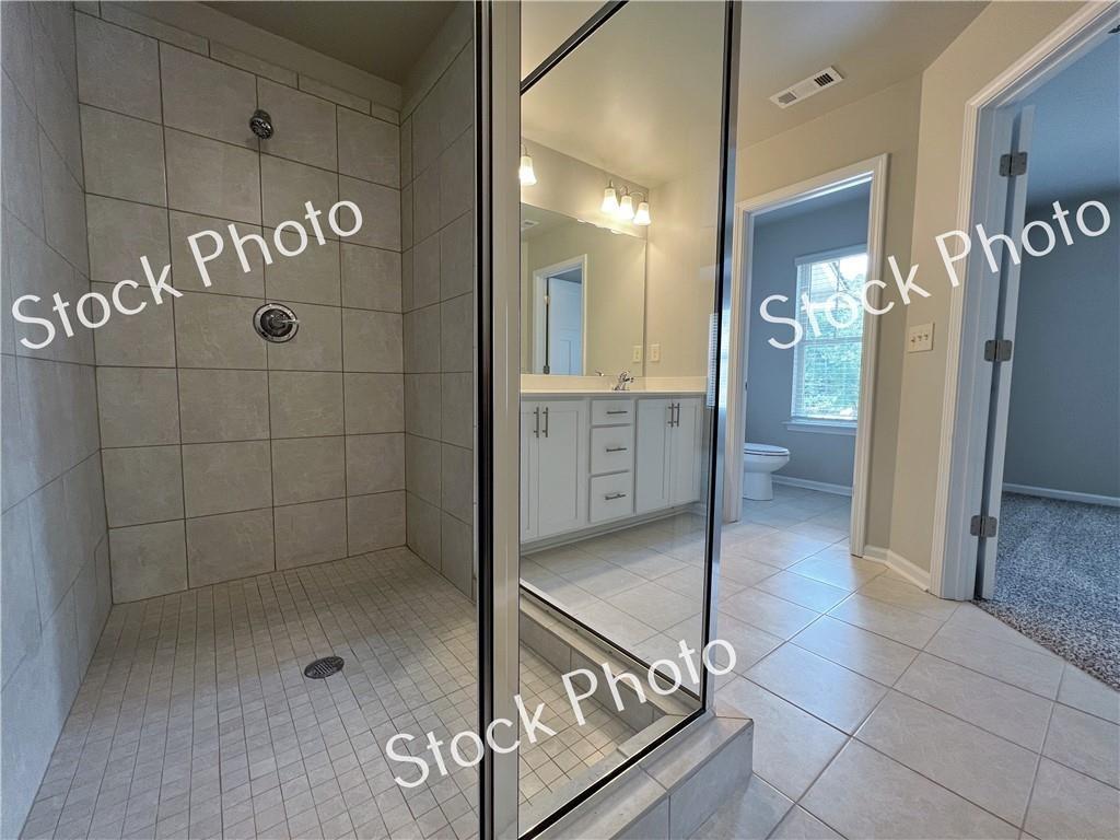 217 Rockfern Terrace Lilburn, GA 30047 - Photo 14 of 16 a bathroom with a glass shower door and a glass door shower