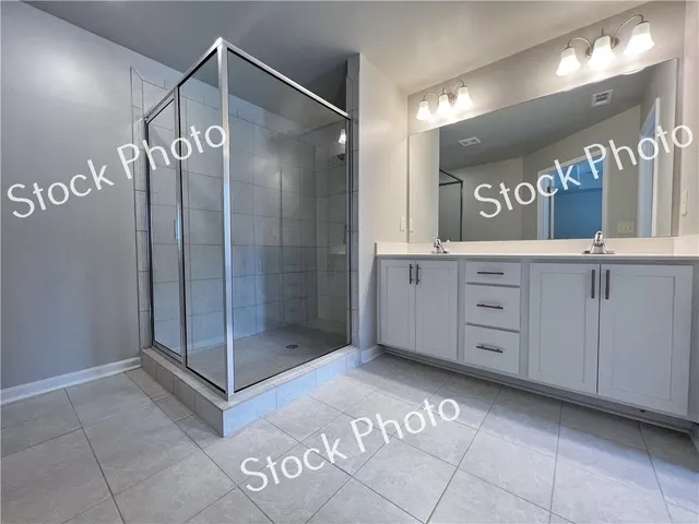a bathroom with a double vanity sink mirror and shower