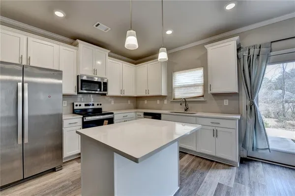 a kitchen with white cabinets and stainless steel appliances