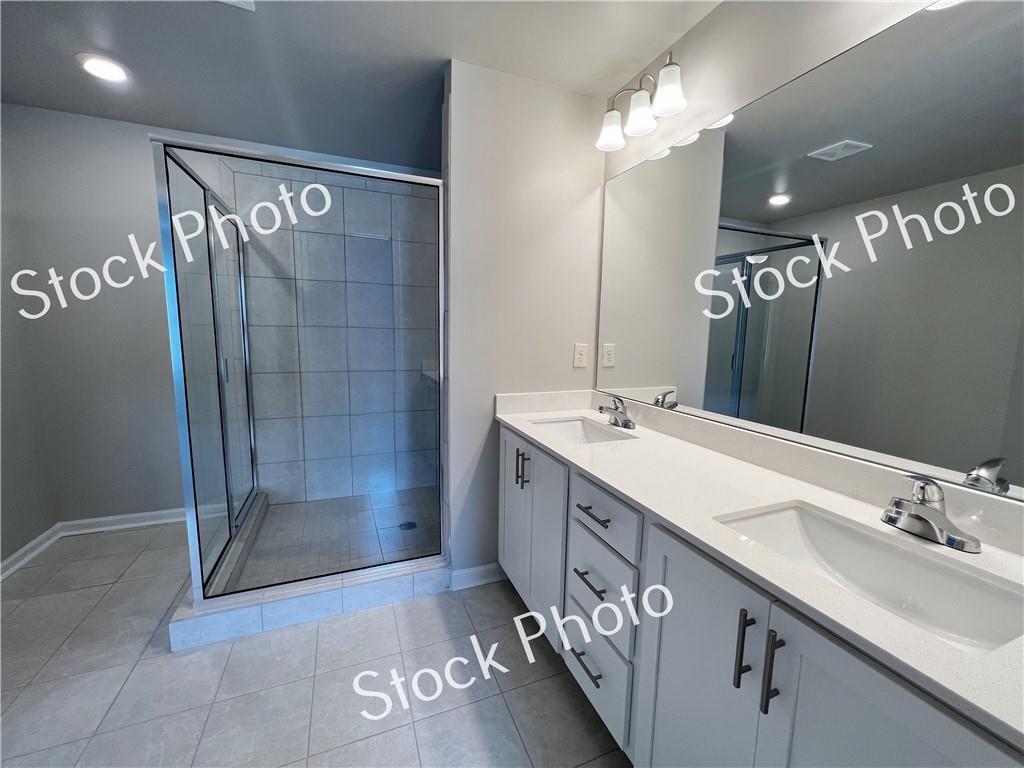 217 Rockfern Terrace Lilburn, GA 30047 - Photo 16 of 16 a bathroom with a double vanity sink mirror and shower