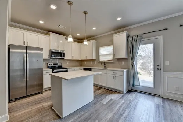 a kitchen with white cabinets and stainless steel appliances