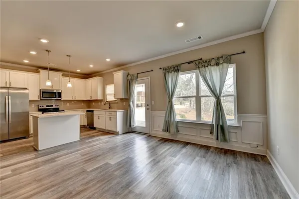 a kitchen with stainless steel appliances kitchen island granite countertop a refrigerator and a stove top oven
