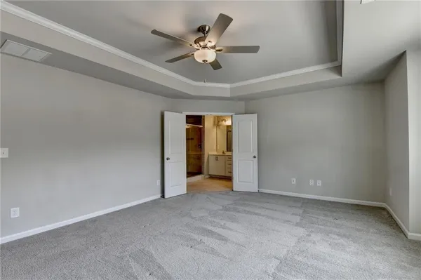 an empty room with windows and ceiling fan