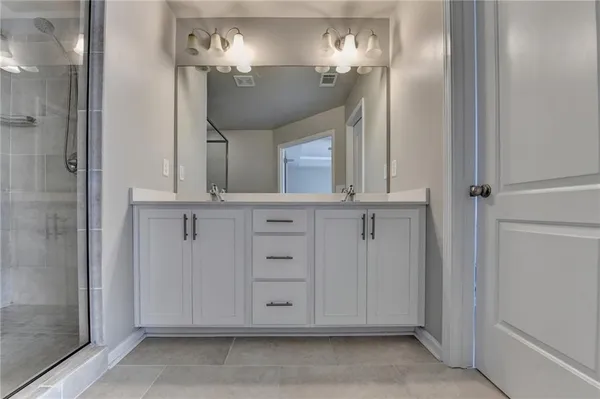 a bathroom with a shower sink and mirror