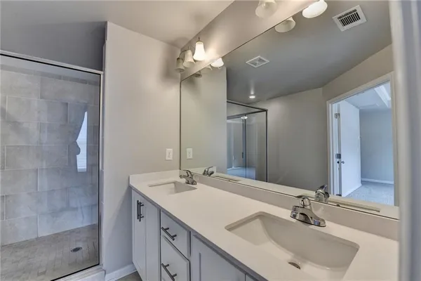 a spacious bathroom with a double vanity sink a toilet and a mirror