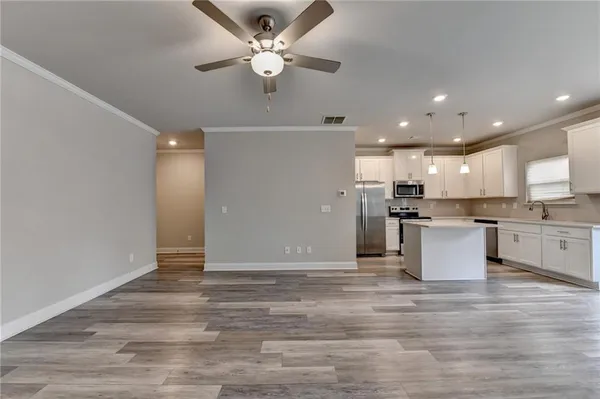 a view of kitchen with granite countertop cabinets and refrigerator