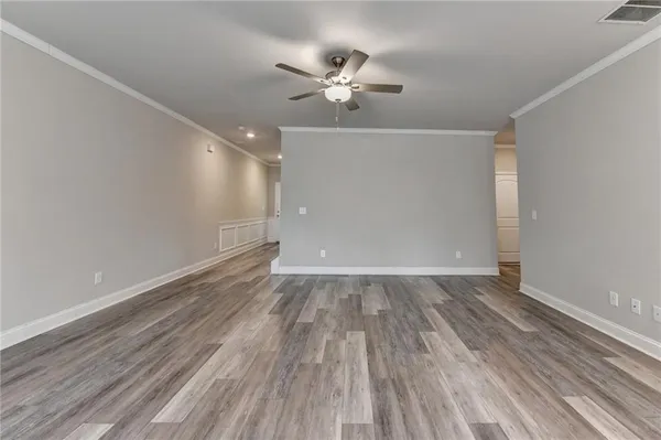a view of a room with wooden floor and a ceiling fan